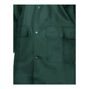 Gros plan sur le tissu PVC souple, les soudures haute fréquence et les poches à rabat du manteau long vert PROS Wear modèle 106.