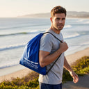 Homme sportif portant le sac a dos cordelette impermeable modele 750 PROS Wear bleu marine tissu PVC Plavitex Classic pour transport d'affaires de sport résistant au UV du soleil