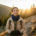 Femme randonneuse portant un tour de cou polaire modele 720 PROS Wear bleu marine lors d'une marche en montagne au coucher du soleil