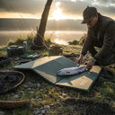 Pecheur utilisant le tapis de peche modele 754 PROS Wear vert en tissu technique PVC deplie au bord de l'eau pour manipuler un poisson en toute sécurité resistance aux UV