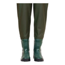 Gros plan : Bottes souples vertes soudées au pantalon PVC du waders junior PROS Wear SB01/J, assurant une étanchéité totale dès le bas de jambe.